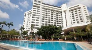 a large building with a swimming pool in front of a building at Eko Hotel Main Building in Lagos