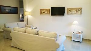a living room with two white couches and a flat screen tv at Guantai 30 in Naples
