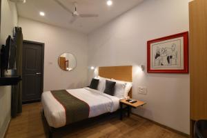 a hotel room with a bed and a mirror at Super Townhouse Royapettah Near U.S Consulate in Chennai +50 photos