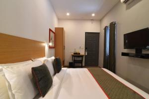 a hotel room with a bed and a television at Super Townhouse Royapettah Near U.S Consulate in Chennai