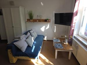 een woonkamer met een blauwe bank en een tafel bij Ferien- und Gästewohnung mit AC in Osterburg Siedlung