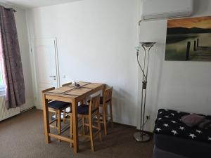 een kamer met een tafel en stoelen en een lamp bij Ferien- und Gästewohnung mit AC in Osterburg Siedlung +2 foto's