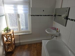 een badkamer met een wastafel en een toilet en een raam bij Ferien- und Gästewohnung mit AC in Osterburg Siedlung