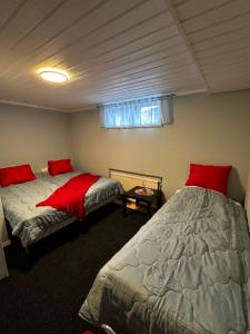 Un dormitorio con dos camas con almohadas rojas. en Good Apartment's Sälen Transtrand, en Transtrand