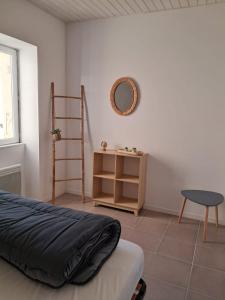 ein Schlafzimmer mit einem Bett, einem Tisch und einem Regal in der Unterkunft Maisons de vacances 6 pers proche plan d'eau in L'Aiguillon-la-Presqu'île
