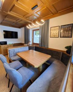 ein Esszimmer mit einem Holztisch und blauen Stühlen in der Unterkunft Hamatli Paznaun in Kappl