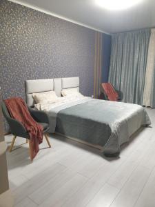 a bedroom with a bed and two chairs at Видові апартаменти на пляжі in Cherkasy