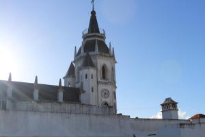 ein Gebäude mit einem Uhrenturm darauf in der Unterkunft Alojamento Bem-me-quer in Reguengos de Monsaraz + 1 Foto