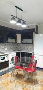 a kitchen with a glass table and two red chairs at Видові апартаменти на пляжі in Cherkasy +17 photos