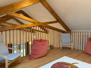 two chairs and a bed in a room with wooden ceilings at Cluain Alainn in Cashel