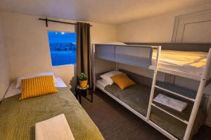 ein Schlafzimmer mit zwei Etagenbetten und einem Fenster in der Unterkunft Hotel Brú countryside in Selfoss + 83 Fotos