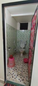 een kleine badkamer met een toilet en een spiegel bij Chaitanya Beach Reesort in Dapoli