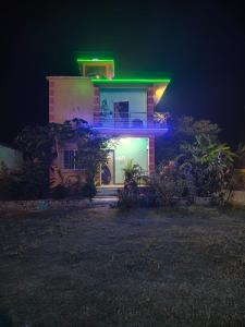una casa con luci verdi sul lato di Regent Resort a Jāmb