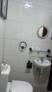 a white bathroom with a toilet and a sink at Eab APARTMENT in Santeo