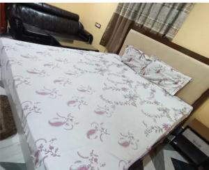 un letto con un copriletto bianco con fiori sopra di Regent Resort a Jāmb Altre 8 foto