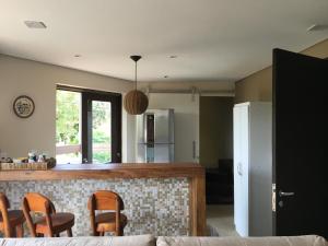 a kitchen with a counter and chairs in a room at Farol da Rata in Fernando de Noronha