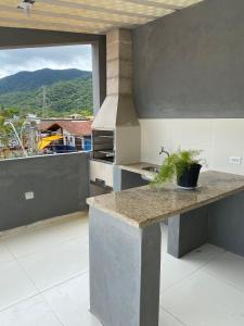 una cucina con bancone e una grande finestra di Casa Marisol Maresias a São Sebastião