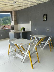 due tavoli e sedie in una stanza con cucina di Casa Marisol Maresias a São Sebastião