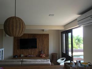 a living room with a couch and a flat screen tv at Farol da Rata in Fernando de Noronha