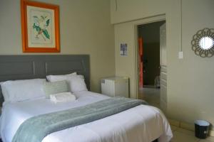 a bedroom with a large white bed in a room at Rural Villa Guesthouse in Naledi