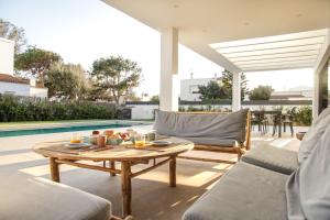 a patio with a coffee table and a pool at s'ANDRONA in Ciutadella
