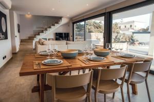 a dining room with a wooden table and chairs at s'ANDRONA in Ciutadella