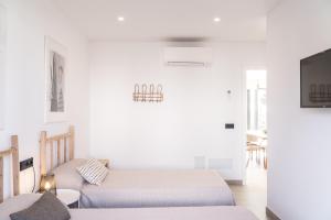 a bedroom with two beds and a couch at s'ANDRONA in Ciutadella