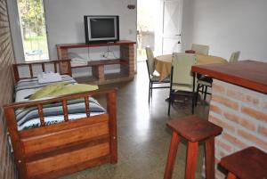 a room with a bed and a table and a tv at El Chinchero Departamentos in Merlo