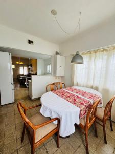 una sala da pranzo con tavolo e sedie e una cucina di Chalet Quintana a Mar del Plata Altre 4 foto