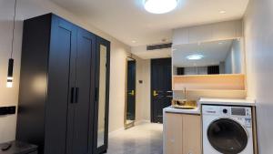 eine Waschküche mit Waschmaschine und Trockner in der Unterkunft Xinyu Hotel - Shanghai Jiao Tong University Xinhua Road in Shanghai