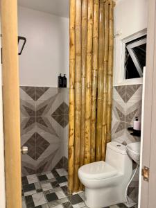 a bathroom with a toilet and a shower curtain at Gym house in San Vicente