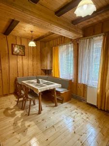 亚列姆切Гуцульська оселя的木墙客房内的厨房配有桌子 更多18张照片