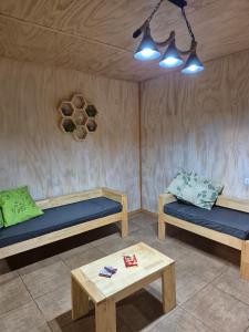 a room with two beds and a coffee table at Hermosa Cabaña en medio de la naturaleza in Los Angeles