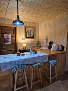 a kitchen with a large table with stools in it at Hermosa Cabaña en medio de la naturaleza in Los Angeles +17 photos