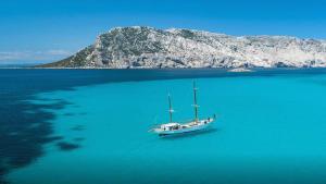 ein Boot inmitten eines großen Wasserkörpers in der Unterkunft Double Suite in Villa with Private Pool San Teodoro in Monte Petrosu