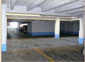 an empty parking garage with white columns and blue accents at Hotel Capri in Guatemala