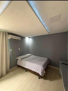 a bedroom with a bed in a room with a ceiling at Quarto Privado Próximo as Praias de Itajaí in Itajaí