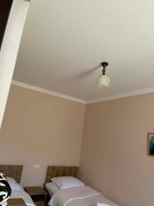 una camera da letto con due letti e un ventilatore a soffitto di Gimara Kazbegi a Kazbegi Altre 2 foto