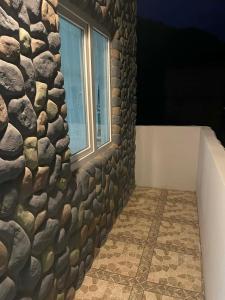 una stanza con un muro di pietra e una finestra di Gimara Kazbegi a Kazbegi