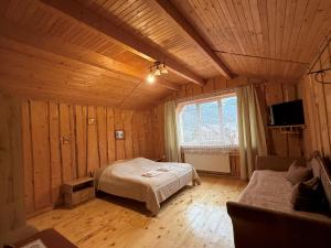 a bedroom with a bed in a wooden room at Гуцульська оселя in Yaremche