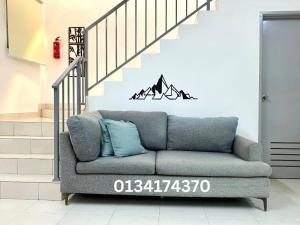 - un canapé dans le salon avec un escalier dans l'établissement Alyn Home Kluang V Netflix, à Keluang