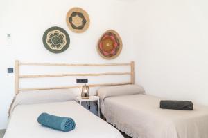 two beds in a room with hats on the wall at s'ANDRONA in Ciutadella +9 photos