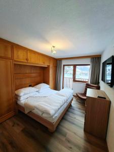 ein Schlafzimmer mit einem großen Bett mit hölzernem Kopfteil in der Unterkunft Hamatli Paznaun in Kappl