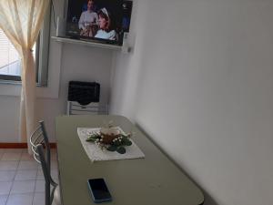 a table in a room with a tv on the wall at Noche Serena in Puerto Madryn