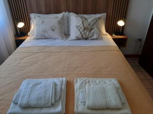 a large bed with two white towels on it at Noche Serena in Puerto Madryn +4 photos