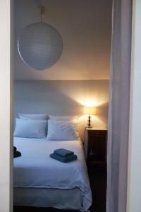 a bedroom with a white bed with a light on it at la chaume st martin in Angoulême