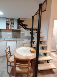 a kitchen and dining room with a table and a spiral staircase at Apartman "Galerija" in Pirot +4 photos