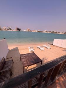 een uitzicht op een strand met stoelen en een tafel bij شالية لابيرلا - درة العروس شاطئ ومسبح خاص in Durat Alarous