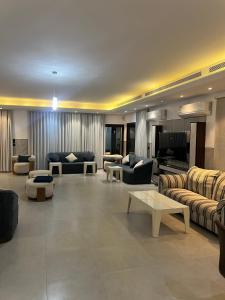 een grote woonkamer met banken en een televisie bij شالية لابيرلا - درة العروس شاطئ ومسبح خاص in Durat Alarous