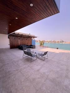 twee stoelen en een tafel op een patio met water bij شالية لابيرلا - درة العروس شاطئ ومسبح خاص in Durat Alarous